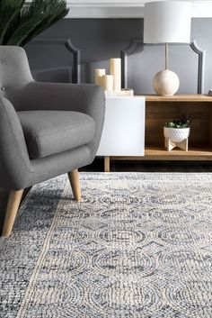 a living room with a gray chair and rug