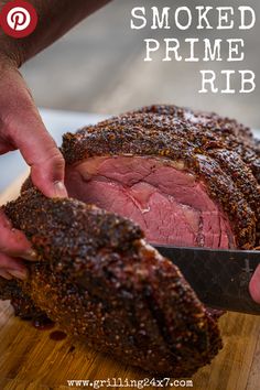 someone cutting up a large piece of meat on top of a wooden cutting board with the words smoked prime rib