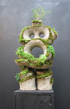 a sculpture made out of cement with moss growing on it