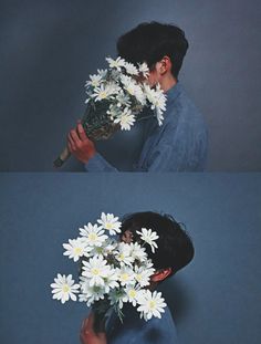 the man is holding a bouquet of daisies up to his face