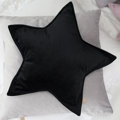 a black star pillow sitting on top of a bed