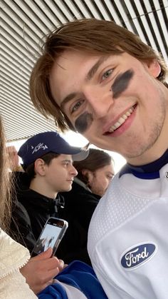 a man with his face painted to look like a football player is taking a selfie