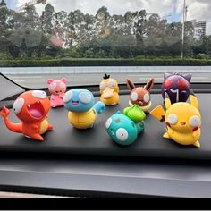 a group of pokemon figurines sitting on top of a car dashboard