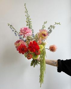 a person holding a bouquet of flowers in their hand