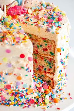 a birthday cake with sprinkles and candles on it's top slice