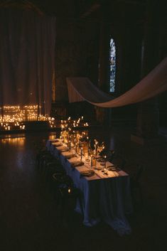 a long table with candles on it in the dark