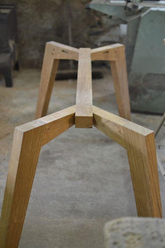 two wooden stools sitting next to each other on top of a cement floor in a room