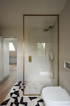 a bathroom with black and white tile flooring next to a walk - in shower