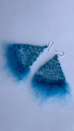 two pieces of blue yarn sitting next to each other on top of snow covered ground