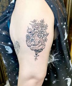 a woman with a tattoo on her arm holding a bouquet of flowers in her hand