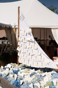 a sailboat made out of cards and flowers is on display at an outdoor event