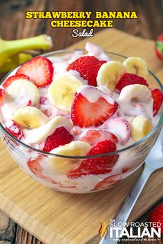 a fruit salad with bananas and strawberries in a glass bowl on a wooden table