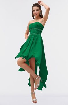 a woman in a green dress posing for the camera with her hand on her hip