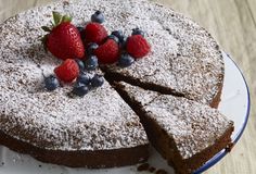 a chocolate cake with berries and powdered sugar on top