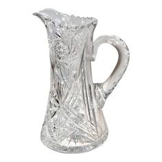 a clear glass pitcher is shown on a white background with no people in the photo