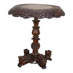 an ornate wooden table with carvings on the top and bottom, sitting against a white background