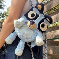 a crocheted stuffed animal in the shape of a bear is held by a woman