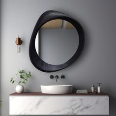 a white sink sitting under a round mirror on top of a counter next to a potted plant