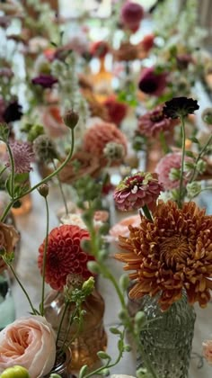 a table topped with lots of vases filled with flowers