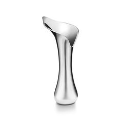 a silver vase sitting on top of a white surface