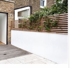 an open door on the side of a brick building with wooden slats and white doors