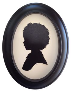 a black and white silhouette of a person in a round frame on a wall with the shadow of a child's head