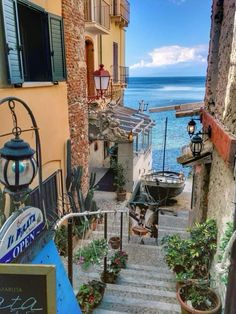 an alley way with stairs leading up to the water