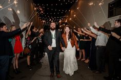 a bride and groom walk down the street with sparklers in their hands as they exit