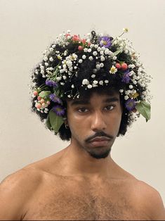 a shirtless man wearing a flower crown on top of his head with no shirt