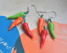 three chili peppers dangling from silver earwires