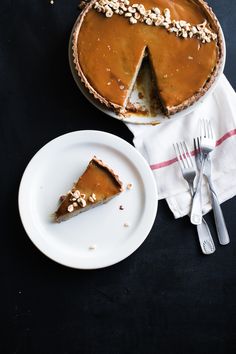 a piece of pie on a plate next to a fork and knife with a slice missing