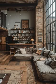 a living room filled with lots of furniture next to a large window covered in books