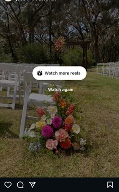 a bunch of white chairs sitting on top of a grass covered field