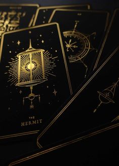 gold foil on black cards with zodiac signs and stars in the sky above them, as if they were playing tarot