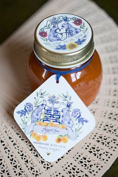 a jar of honey sitting on top of a doily next to a small tag