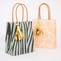 two zebra print bags with gold handles on each one and a giraffe print bag on the other