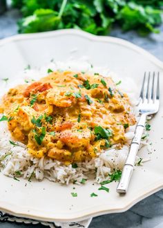 a white plate topped with rice and chicken curry