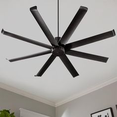 a black ceiling fan in a white room