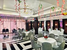 a room with tables, chairs and chandeliers decorated in black and white stripes