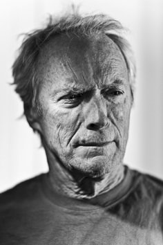 black and white photograph of an old man with wrinkles on his face, looking at the camera