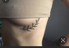 a woman with a tattoo on her stomach has an arrow and leaves tattooed on her side