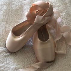 two pairs of ballet shoes with bows on them