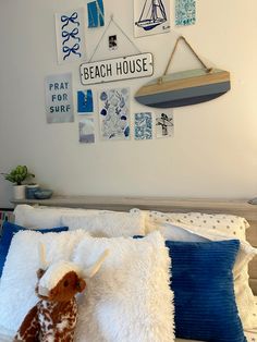 a stuffed animal laying on top of a bed in a bedroom next to a wall with pictures