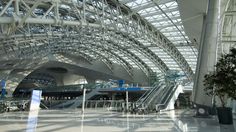 an airport terminal with several escalators and stairs