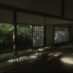 an empty room with benches and windows in the sun shining through them to light up the floor