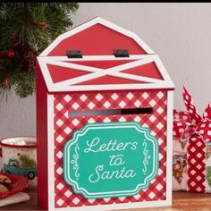 a red and white mailbox sitting on top of a table next to christmas decorations