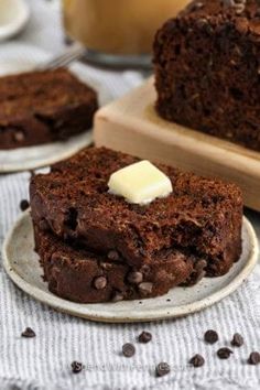 a piece of chocolate cake on a plate next to some coffee beans and a glass of milk