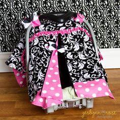 a black and white bag with pink polka dots on it sitting in front of a wall