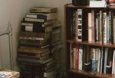 a bookshelf filled with lots of books next to a lamp