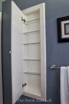 an empty bathroom with blue walls and white towels on the rack in front of the shower